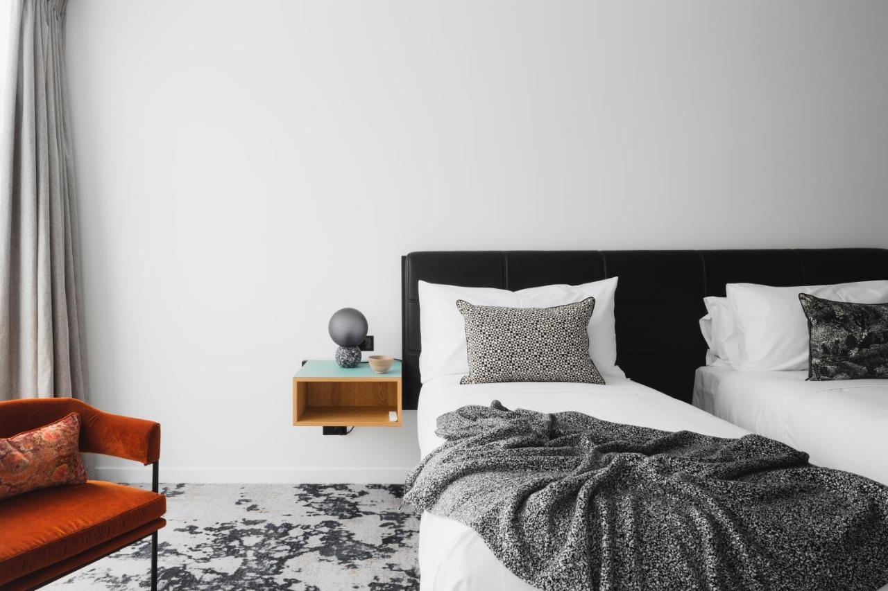 Ebb-Dunedin Eksteriør bilde A bedroom with a bed, a chair and a nightstand